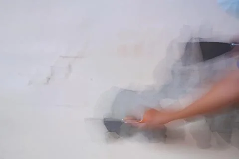 Blurry Working Concept. Removing old paint from the old wall by hand with a m Foto stock