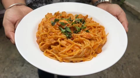 Blushing spaghetti with chicken served in a white plate in Kolkata Stock Footage 311684115