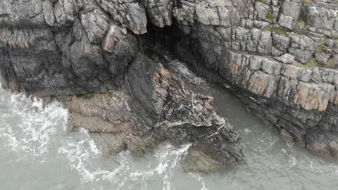 Blustery Cliffs and Cave with Waves Stock Footage 194501228