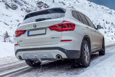   BMW X 3 auf einer schneebedeckten Straße in den Bergen (Composing) *** B.. Stock Photos