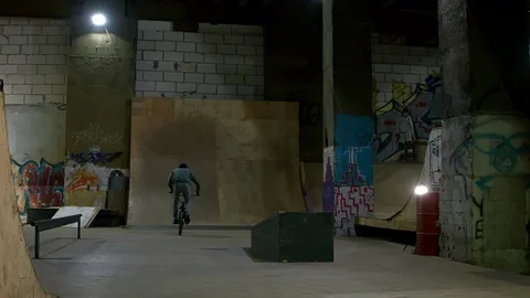 BMX Athlete Doing Tricks in underground skatebord park Stock Footage 86175284