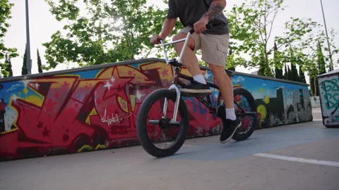 BMX rider approaching and performing foot trick ending in close up detail slow Stock Footage 336937049