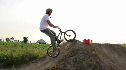 Bmx rider crashes trying a tailwhip on a dirt jump Stock Footage