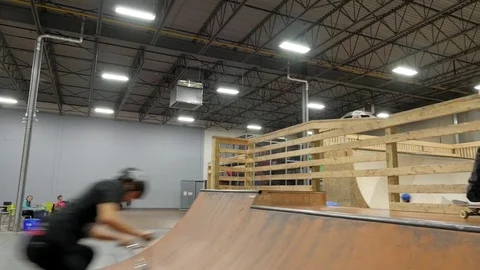BMX rider does 360 and lands backwards on ramp at skatepark Stock Footage 72904680