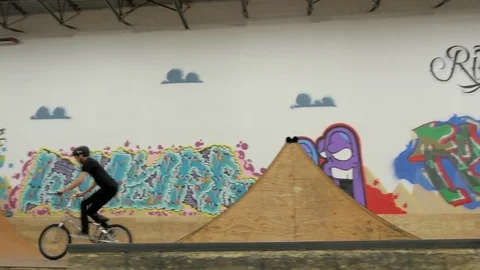 BMX rider does 360 bar spin, no hander and 180 with bar spin at skate park. Video stock 72904775