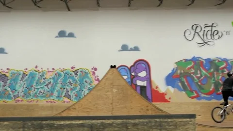 BMX rider does 360, bar spin, and no hander at skate park. Stock Footage 72904777