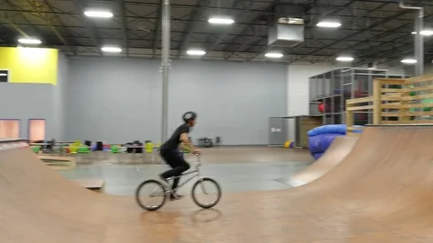 BMX rider does no hander, tail whip and 180 wheelie at skate park Stock Footage 72904826