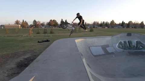 Bmx rider does tail whip on jump at skate park in slow motion Stock Footage 119983589