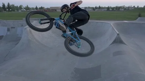 A bmx rider does trick in air at skate park in slow motion Stock Footage 119983023