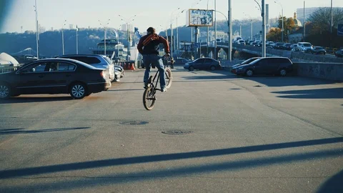 BMX rider doing 360 spin trick riding the city. Outdoor with autumn color Stock Footage 98230289