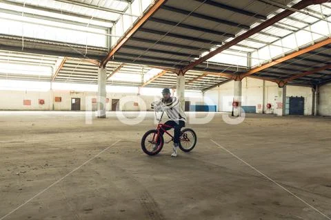 BMX rider in an empty warehouse Stock Photos