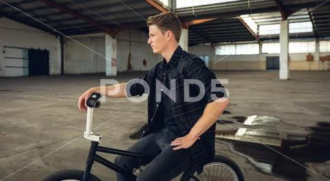 BMX rider in an empty warehouse Stock Photos