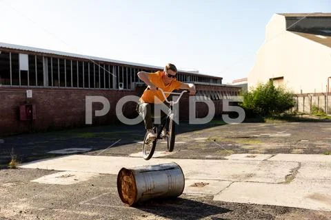 BMX rider jumping in an empty yard Stock Photos