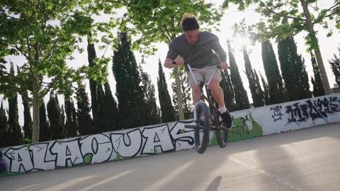 BMX rider performing consecutive spins and jumps in skatepark slow motion Stock Footage 337220531