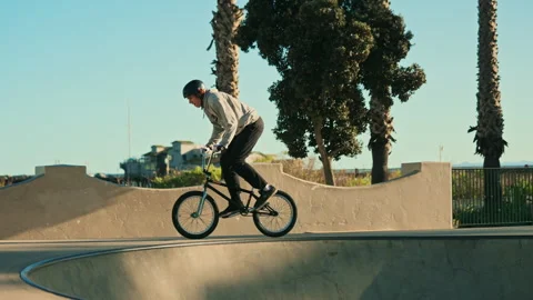 A BMX rider performing tricks at a skate park in Santa Barbara - slow motion 4k Stock Footage 345011908