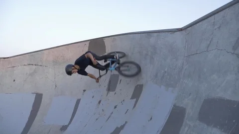 A bmx rider performs a wall ride trick at skate park in slow motion Stock Footage 119982853