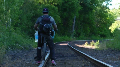 Bmx rider rolls down train track Stock Footage 27693044