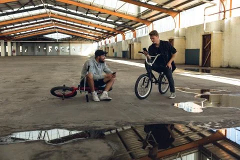 BMX riders in an empty warehouse Stock Photos