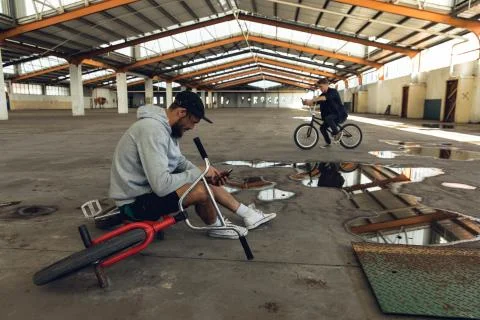 BMX riders in an empty warehouse Stockfoto's
