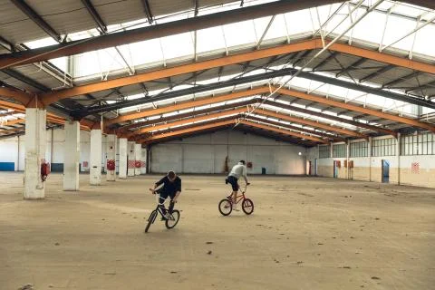 BMX riders in an empty warehouse Stock Photos