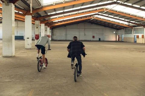 BMX riders in an empty warehouse Stock Photos