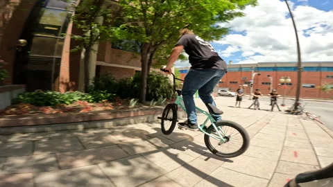 BMX street trick jumping off ledge 180 Stock Footage 242178535
