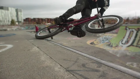 BMX tire slide on a half pipe in concrete skatepark Stock-Footage 141828062