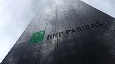 BNP Paribas logo on a skyscraper facade reflecting clouds, time lapse. Editorial Stock Footage 81077796