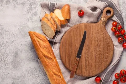 Board, bread and tomatoes for making sandwiches Stock Photos
