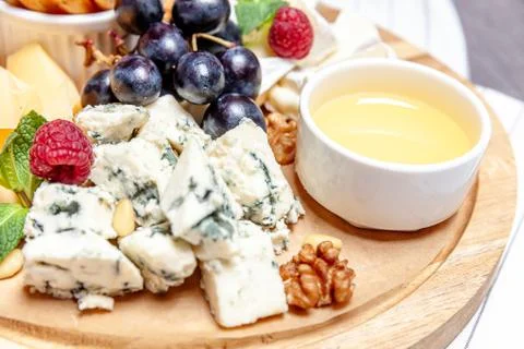 Board with different types of cheese. Cheeses mix set dor blu chedar parmesan Stock Photos