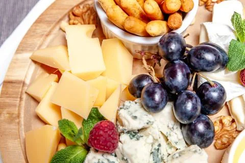 Board with different types of cheese. Cheeses mix set dor blu chedar parmesan Stock Photos