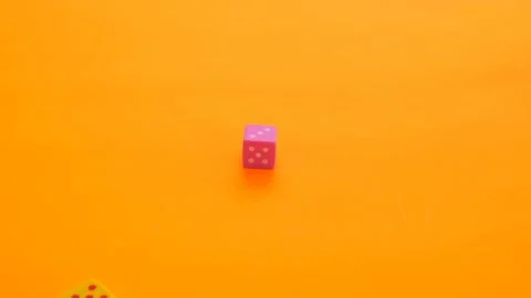 Board games concept.Multicolored cubes slowly fall on a bright orange background Stock Footage 145926278