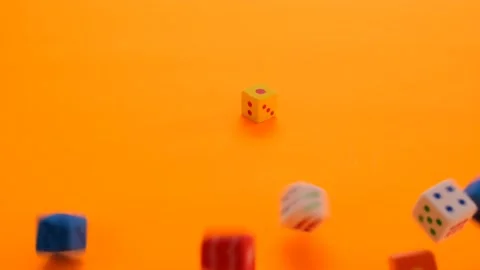 Board games. Multicolored cubes slowly fall on a orange background Vidéo 145926269