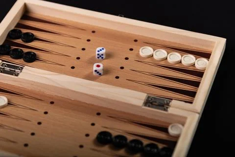 Board for playing backgammon with pieces and dice on a black background. 写真素材