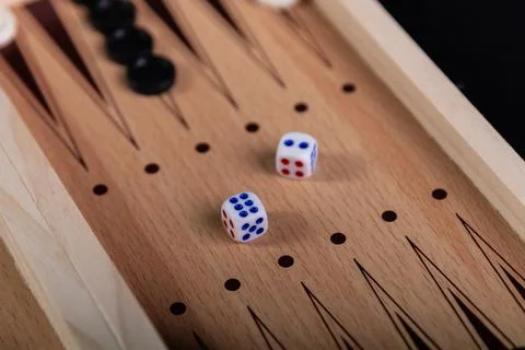 Board for playing backgammon with pieces and dice on a black background. 写真素材