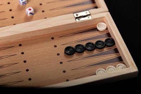 Board for playing backgammon with pieces and dice on a black background. 写真素材
