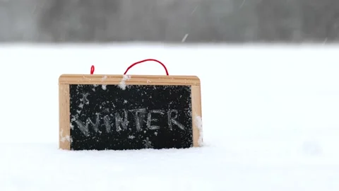 Board with winter text snow falling Stock Footage 162559784