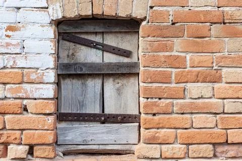 Boarded-up window against the red brick wall, place under the text Stock Photos
