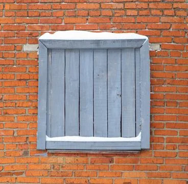 A boarded up window on a brick wall background Stock Photos