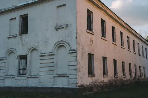 Boarded-up windows of an old abandoned building. Evening sunlight Stock Photos