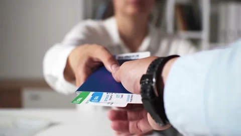 A boarding pass for an airplane is held out by a travel agent girl. Air tick Stock Footage 198734570