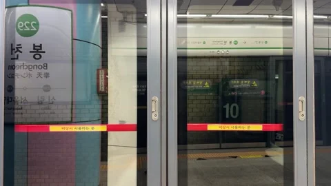Boarding the train through safety screen doors at subway station on Seoul Metro Stock Footage 342333693