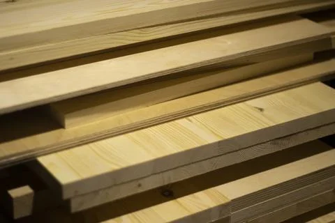 Boards in the carpentry workshop. The tree lies in a pile. Stock Photos