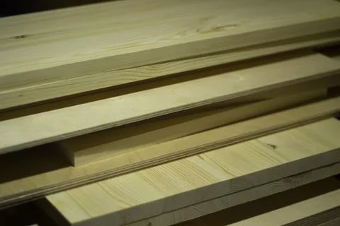 Boards in the carpentry workshop. The tree lies in a pile. Stock Photos