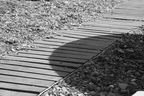 Boardwalk on a pebbled beach Stock Photos