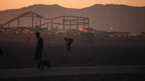 Boardwalk Pedestrians on Beach with Mountains and Rollercoaster 動画素材 22391053
