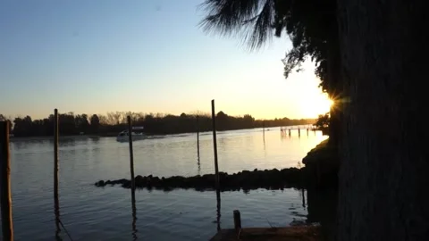 Boat and sun in river at sunset Stock Footage 196447434
