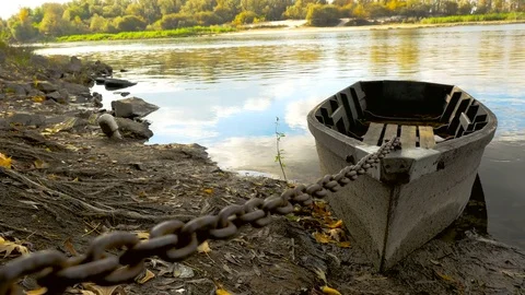 The boat is attached by a chain to the shore Stock Footage 71256301