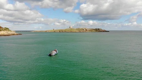Boat on bay fly past towards and island Stock Footage 101657423