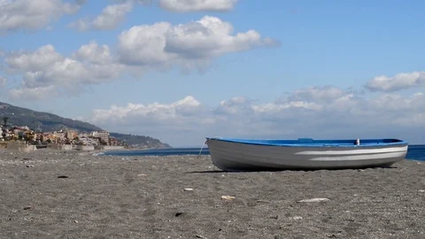 A boat on the beach and in the background the coast of Sicily near Taormina Stock Footage 88208513